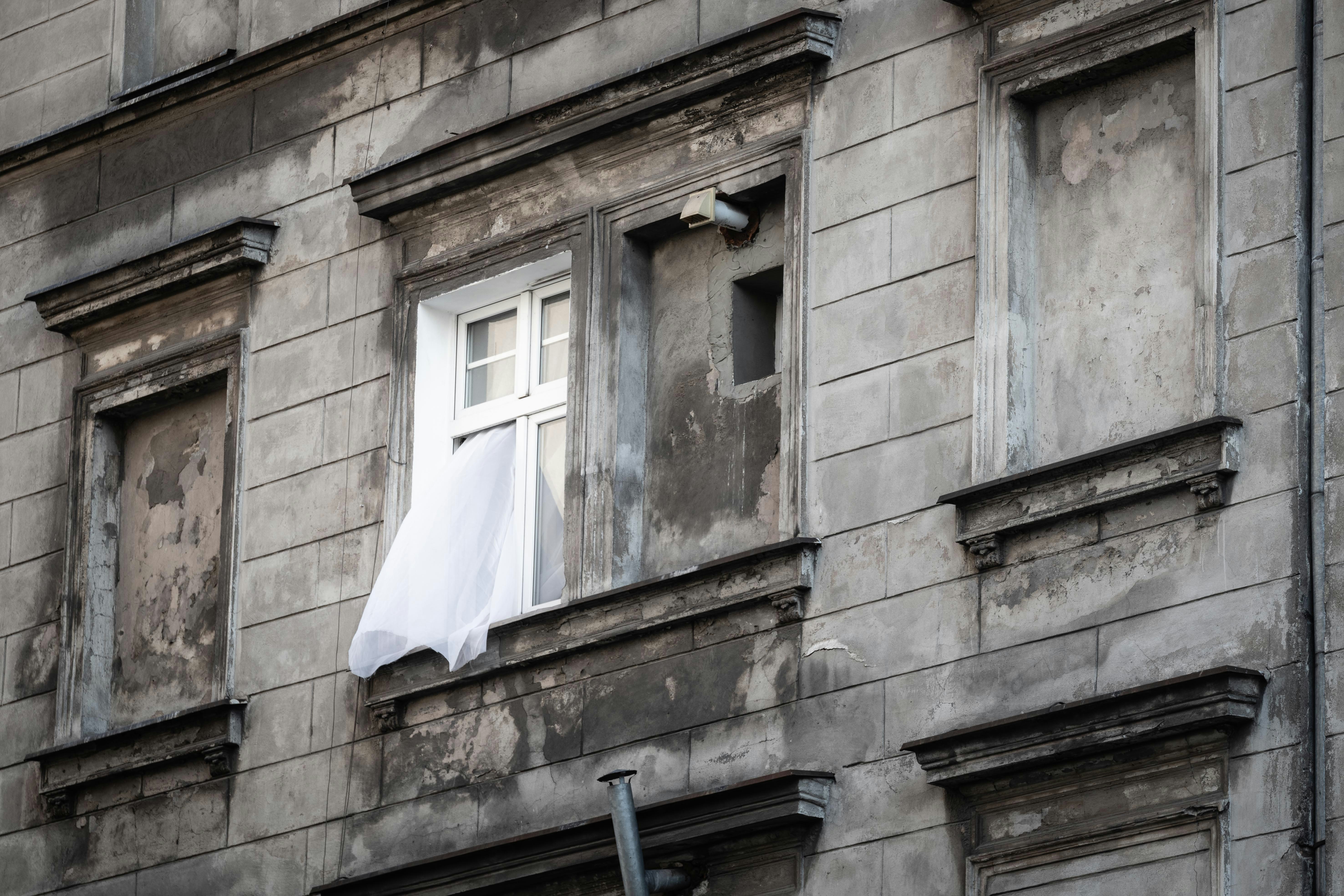 white sheer curtain out from glass window